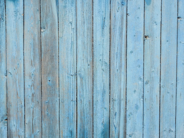 Tablones de madera antiguos pintados con pintura azul descascarada.