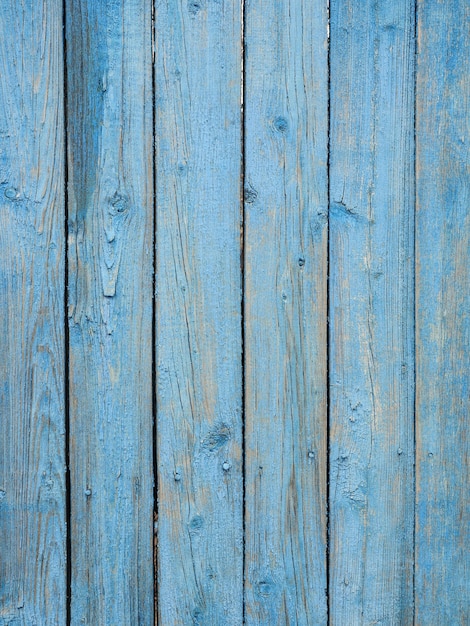 Tablones de madera antiguos pintados con pintura azul descascarada.