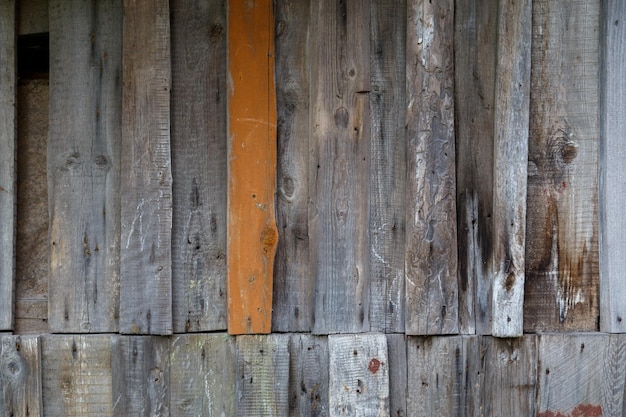 Tablones de madera desordenados grises verticales con una textura y fondo de superficie de pared marrón