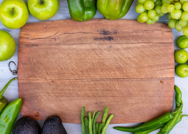 Táboa de cortar de madeira com vegetais na moldura