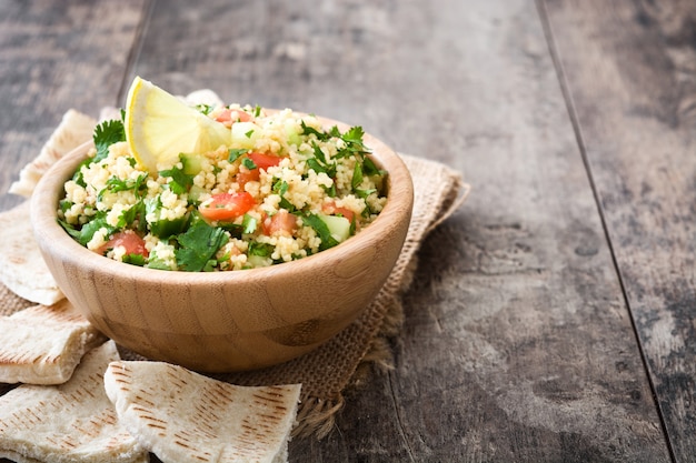 Tabouleh-Salat mit Couscous auf Holztisch