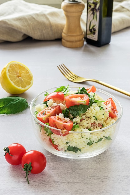 Tabouli caseiro fresco ou salada de tabule com vista lateral de seus ingredientes na superfície cinza