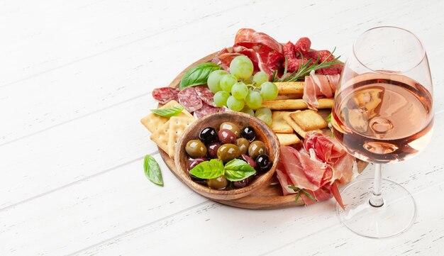 Foto tábua de antepasto com queijo prosciutto salame biscoitos e azeitonas