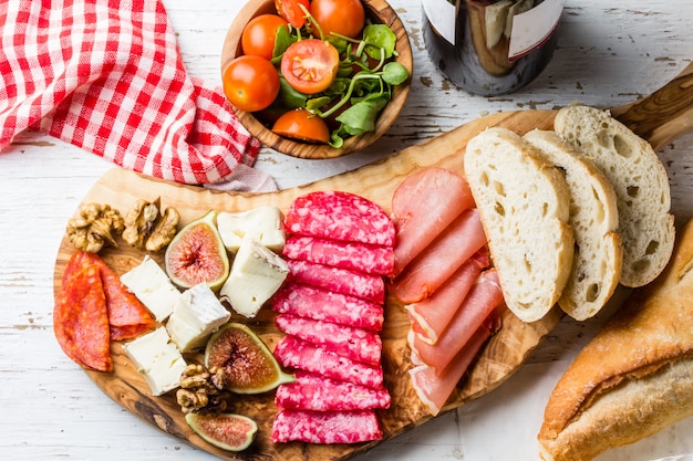 Tábua de azeitona com salame, presunto serrano, queijo, nozes e pão ciabatta