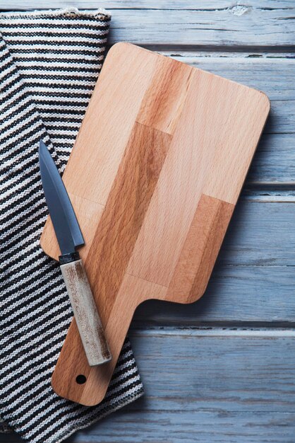 Tábua de cortar de madeira e pano em uma mesa de prancha de madeira rústica