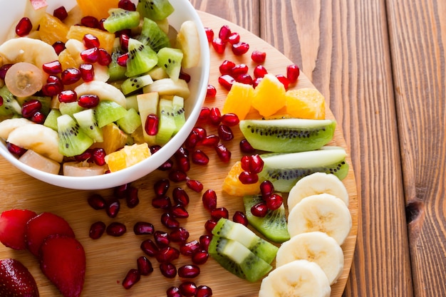 Tábua de cortar salada de frutas em um de madeira