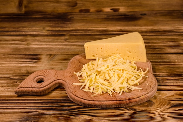 Tábua de corte com queijo ralado na mesa de madeira rústica