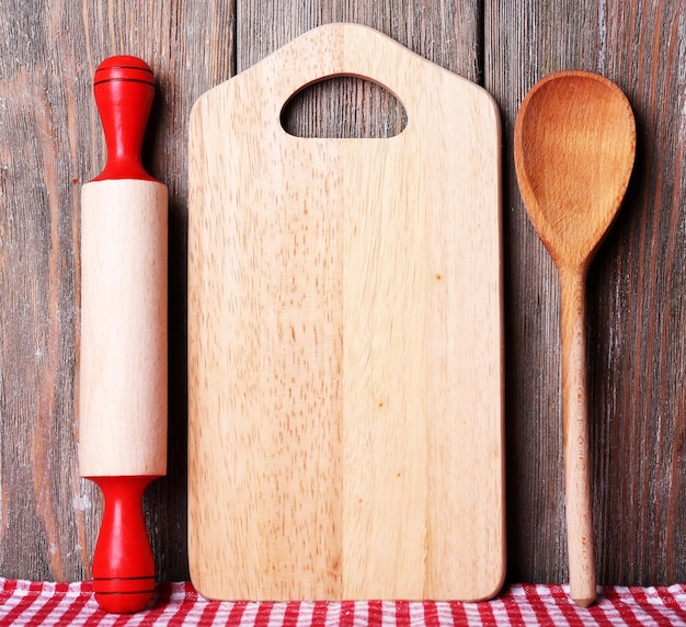 Tábua de corte com tomate cereja e alface em fundo de pranchas de madeira
