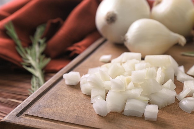 Tábua de madeira com cebola fatiada na mesa fechada