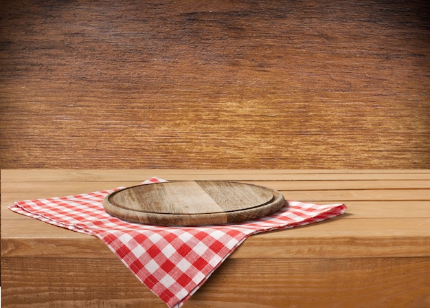 Tábua de madeira e pano de saco na mesa de madeira