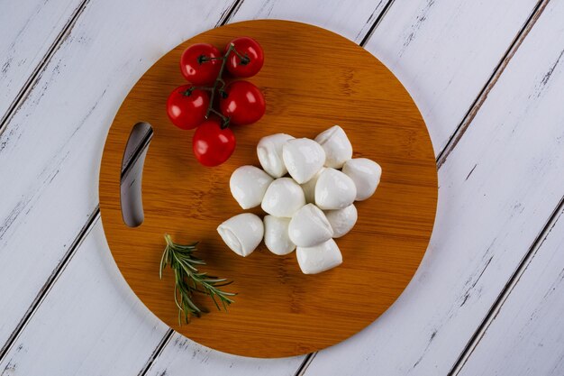 Foto tábua redonda com bolinhas de mussarela de búfala e tomate cereja