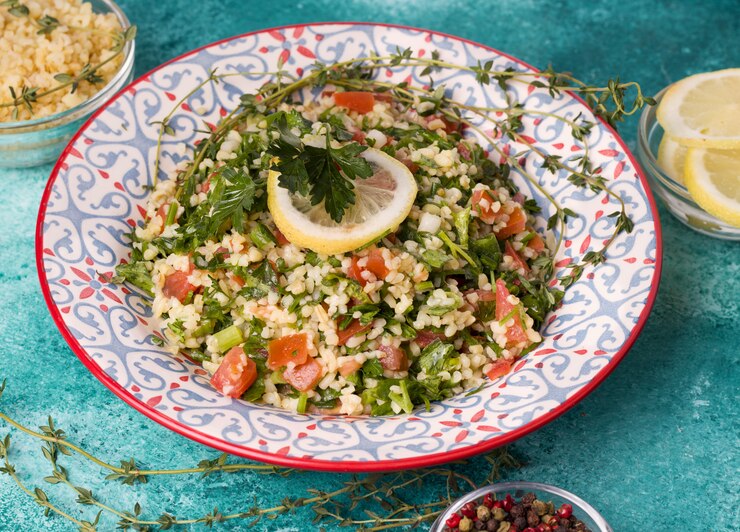 Foto tabule - salada oriental, aperitivo em um plano de fundo azul ao lado dos ingredientes