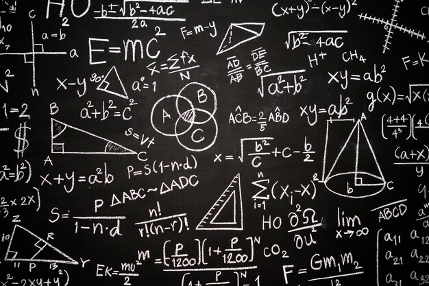 Foto tabuleiro com inscrições de fórmulas e cálculos científicos em física, matemática e circuitos elétricos