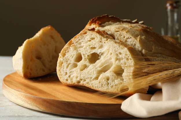 Tabuleiro com pão fresco em fundo branco de madeira