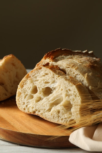 Tabuleiro com pão fresco em fundo branco de madeira