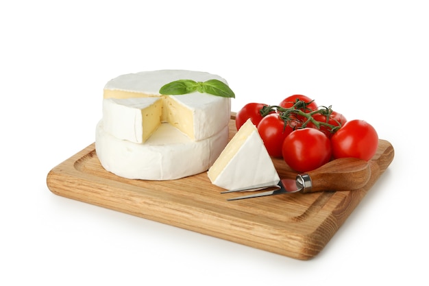 Tabuleiro com queijo camembert, manjericão, faca e tomate isolado no fundo branco