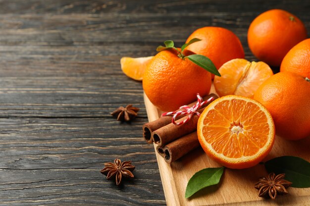 Tabuleiro com tangerinas e canela em madeira