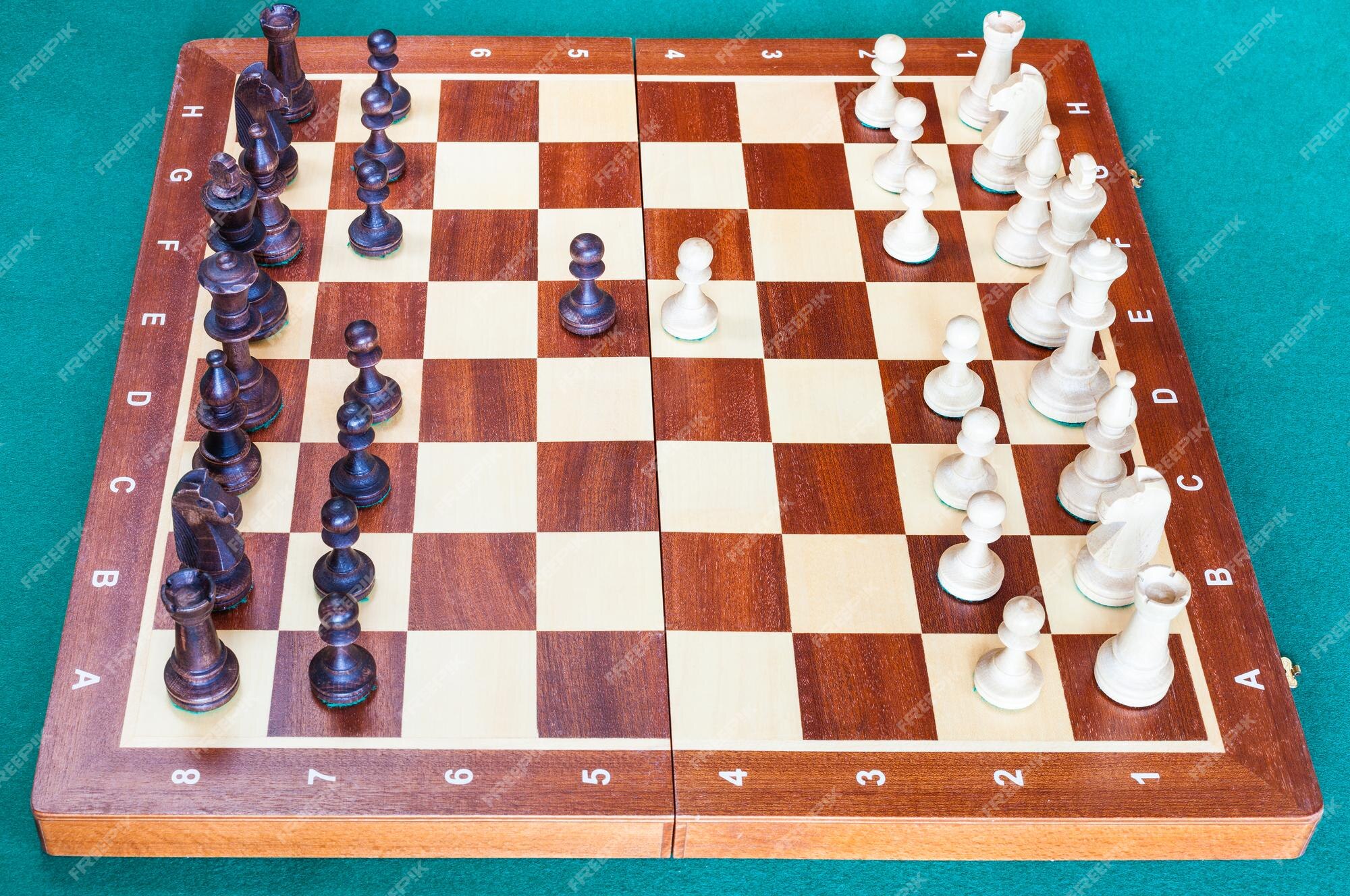 Tabuleiro de xadrez de madeira com os primeiros movimentos do