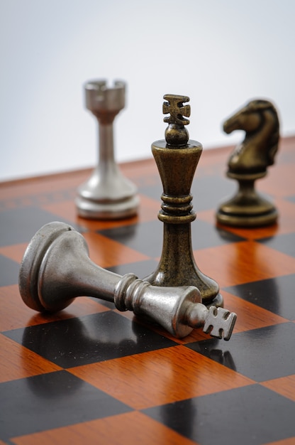 Tabuleiro de xadrez de madeira com peças de metal. Xeque-mate.