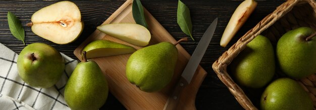 Tabuleiro e cesto com peras verdes em madeira