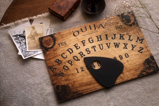 Foto tabuleiro ouija de madeira de alto ângulo e velas