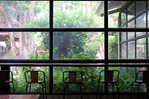 Taburete en cafetería cafetería junto a la ventana del jardín