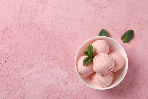 Taça com sorvete e hortelã na superfície rosa