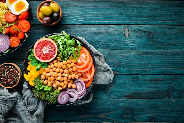 Taça de Buda. Ervilhas turcas, brócolis, tomate, cebola. Vista do topo. Espaço livre para o seu texto.