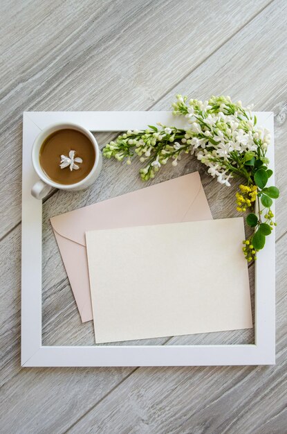 Foto taça de café estrutura de madeira branca e maquete e copyspace envelopes cor-de-rosa pastel e cartão em branco