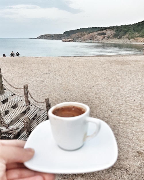 Foto taça de café na mesa do mar contra o céu