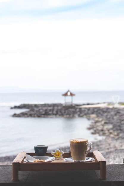 Foto taça de café na mesa do mar contra o céu