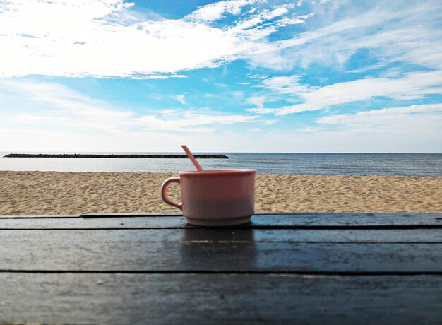 Foto taça de café na mesa do mar contra o céu