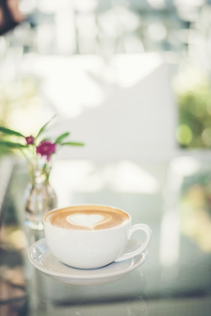 Taça de café servida em uma mesa de vidro