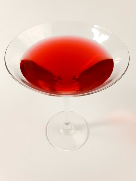taça de vinho com martini vermelho no fundo branco