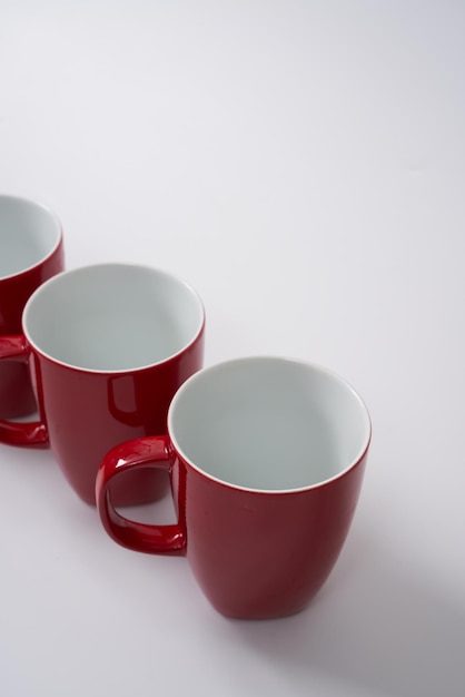 Taças de café ou chá de cerâmica vermelha sobre fundo branco