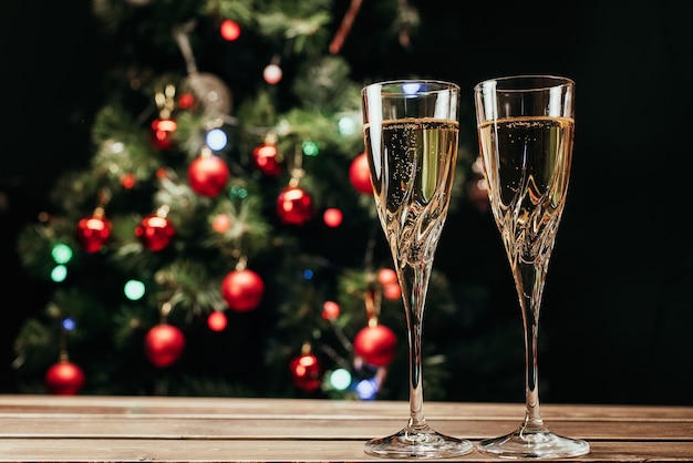 Taças de champanhe no fundo de uma árvore de Natal decorada. Ano Novo