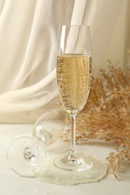 Taças de champanhe, resina epóxi e flores do campo na mesa branca