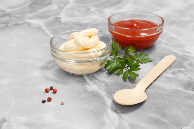 Taças de vidro com molho de ketchup e queijo na mesa da cozinha.