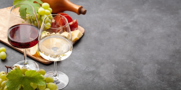 Taças de vinho branco e tinto uva e tábua de aperitivos