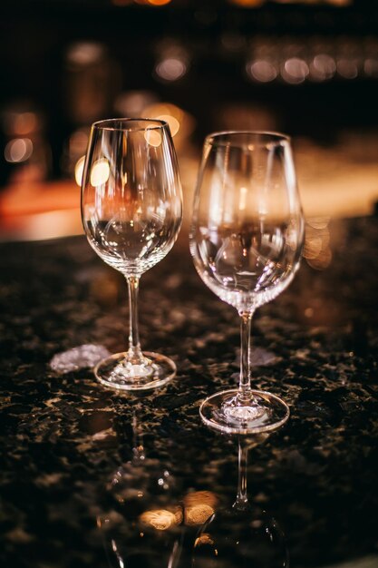 Taças de vinho transparentes com bokeh de luzes brilhantes. Óculos em um fundo claro