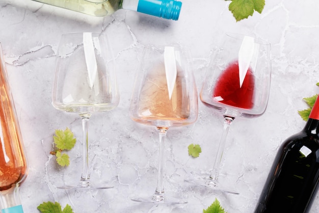 Taças e garrafas de vinho tinto e rosa branca