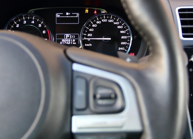 Tachometer-Hintergrundbeleuchtung auf einem Armaturenbrett in modernen Autos mit weichem Fokus auf dem Lenkrad