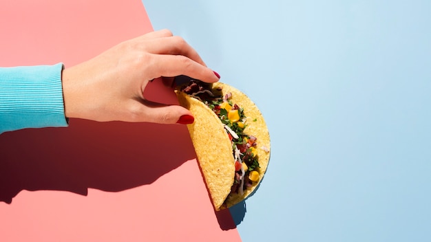 Taco de vista superior com carne e legumes na mão