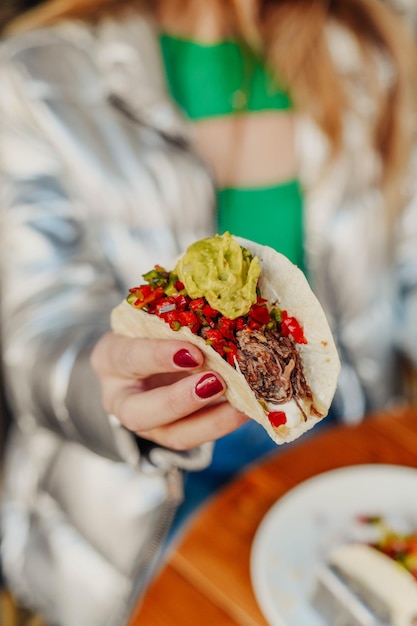 Foto taco mexicano hecho con carne de cerdo triturada y guacamole