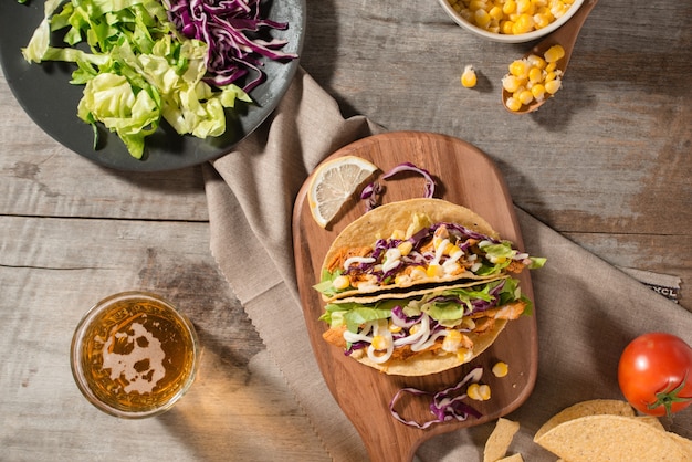 Taco mexicano tradicional con pollo y verduras en mesa de madera. Comida latinoamericana.