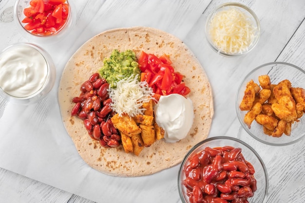 Taco con relleno de pollo y verduras en el fondo de madera