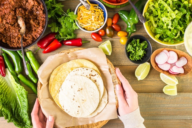 Tacos de carne molida con lechuga romana, tomates cortados en cubitos, rábanos y queso cheddar rallado.