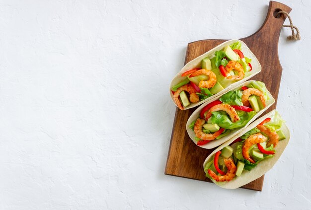 Tacos com camarão, abacate e salada. Comida mexicana.