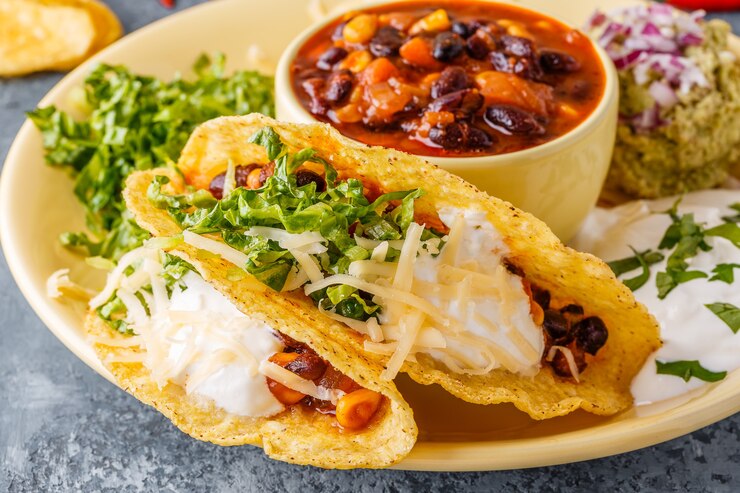 Foto tacos com chili com carne, salada, queijo e creme de leite, foco seletivo.