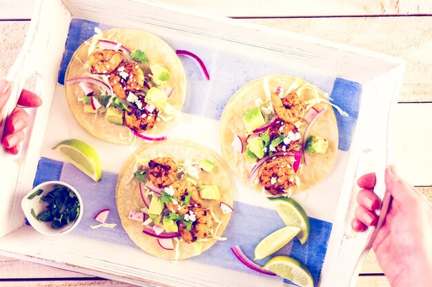 Tacos de camarão com chipotle fresco com queijo cotija em uma tortilhas de milho branco.